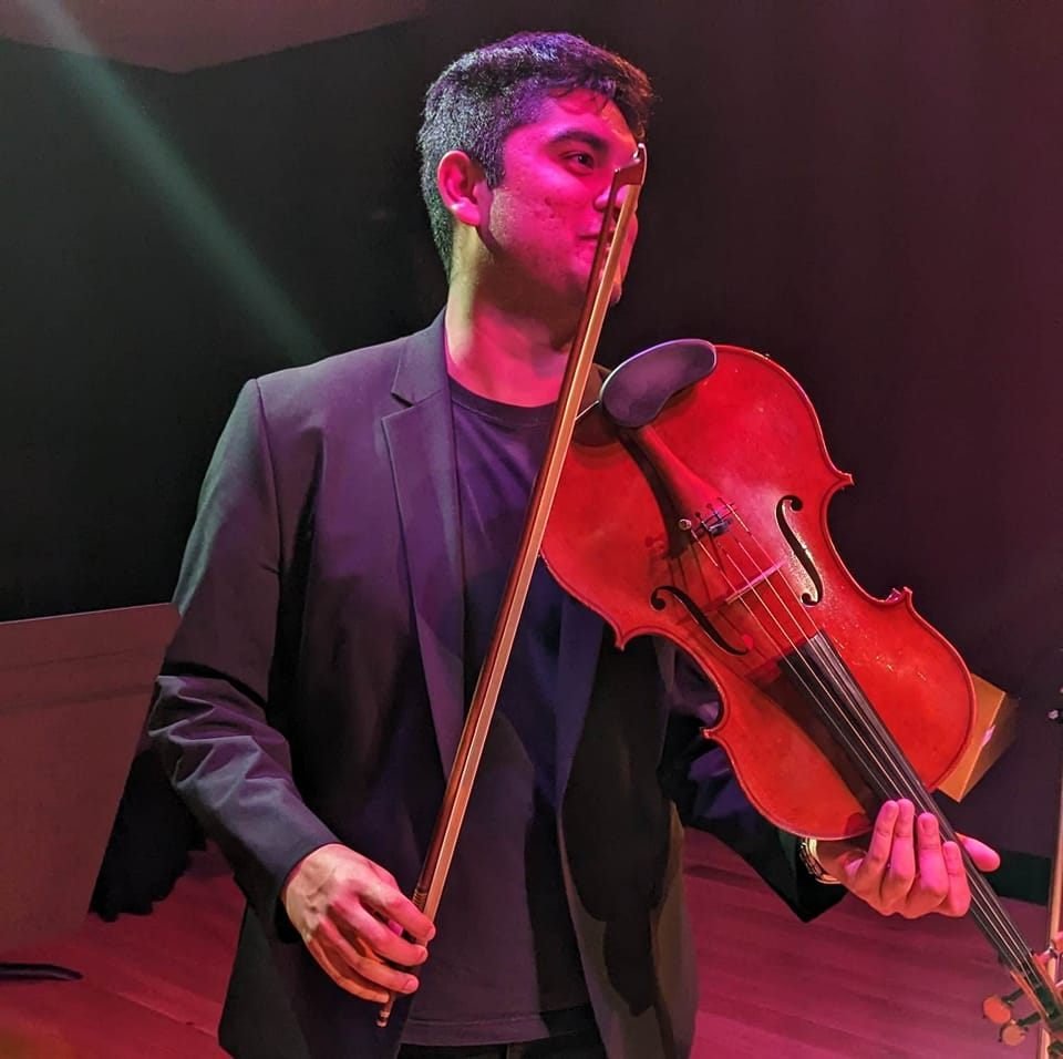 Rohan Joshi holding his viola onstage